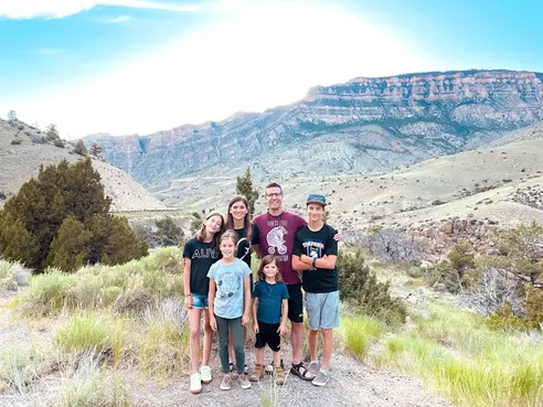 All six of them together on a sagebrush hillside, the layered cliffs of the Big Horns filling the view behind