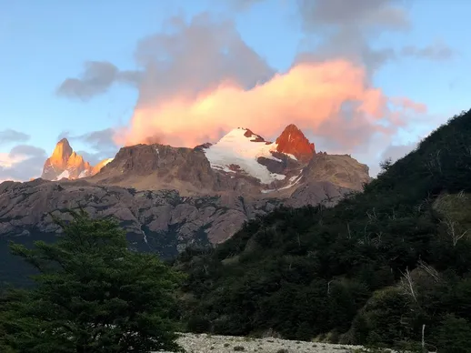 Mount Fitz Roy at sunrise, the cloud above it lit orange and the snowfields catching the first light