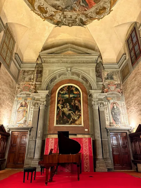 The chapel set for the recital, a grand piano on a red carpet below a frescoed altarpiece and a painted dome