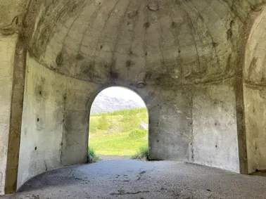The inside of one of the concrete domes, its curved roof overhead and the mountain framed in the arched doorway