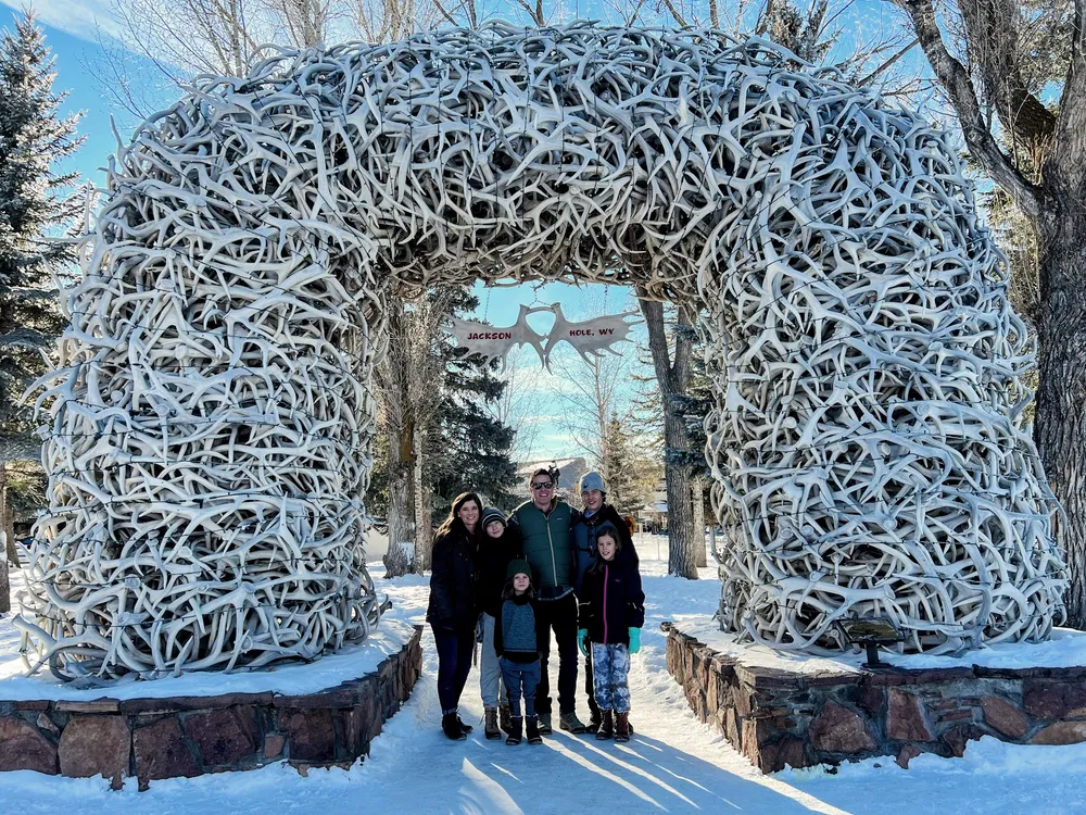 The family gathered under one of the elk antler arches on the Jackson town square in winter, snow banked along the pavement