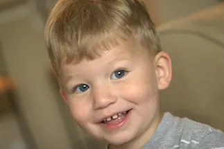 Preston as a toddler with a blond fringe, grinning at the camera