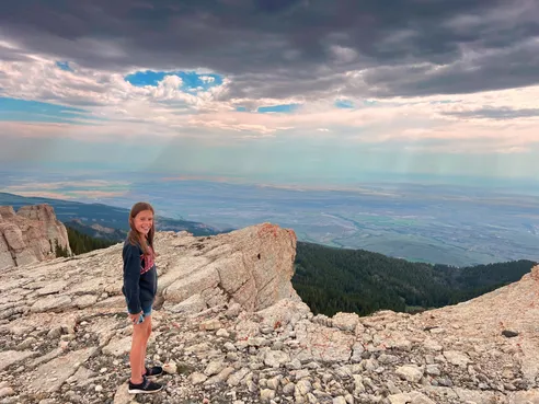 Mia on the pale rock at the top of the escarpment, the basin spread out thousands of feet below her